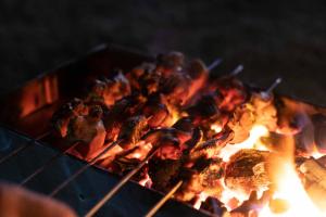 a bunch of food cooking on a grill at StayVista at Water's Edge with Sprawling River Views in Chak-i-Dāra