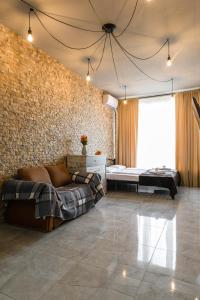 um quarto com um sofá e uma parede de tijolos em Смарт-студія в центрі біля парку em Uzhhorod