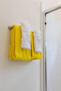 a towel rack with yellow and white towels on it at Luxurious 3-BDRM/King Bed/Gated/Near Ocho Rios in Boscobel