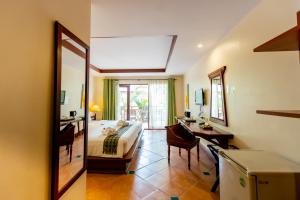 Ao Nang Bay Resort في شاطيء آونانغ: غرفة نوم بسرير ومكتب ومرآة