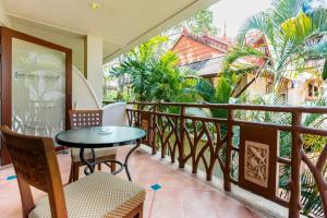 een balkon met een tafel en stoelen en palmbomen bij Ao Nang Bay Resort in Ao Nang Beach