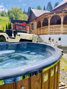 a hot tub in front of a house at Cabana Bogdi in Borşa