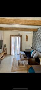 a living room with a couch and a table at modern rustic house in the heart Of the village in Kefalos