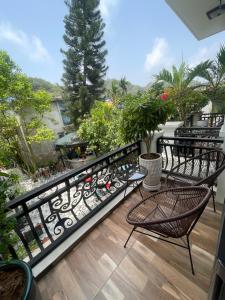 einen Balkon mit Stühlen und Gartenblick in der Unterkunft Lynh's Villa in Cát Bà