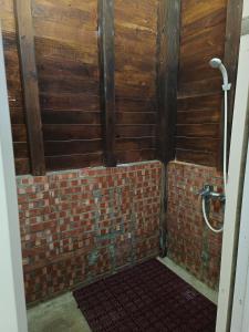 a bathroom with a brick wall and a shower at Traveller Mountain Spring Farm in Beipu