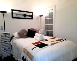 a bedroom with a large bed with towels on it at Ground Floor Centrally Located Apt 22 - Smugglers Inn in Victor Harbor