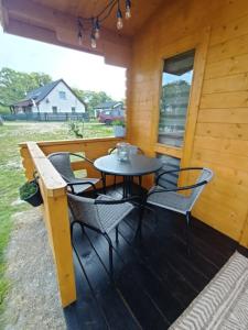 una mesa y sillas en el porche de una cabaña en Domek nad stawem, en Golczewo