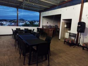 una sala da pranzo con tavoli, sedie e una grande finestra di Casa D'Lucas a Puerto Baquerizo Moreno