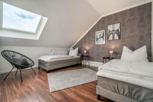 a bedroom with two beds and a chair at - DESIGN & STYLE - Modern House with terrace & garden in Wesel