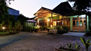 una casa con un banco delante de ella en Sleepy Raccoon Hostel en Yogyakarta