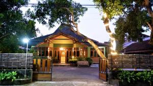 a house with a gate in front of it at Sleepy Raccoon Hostel in Yogyakarta