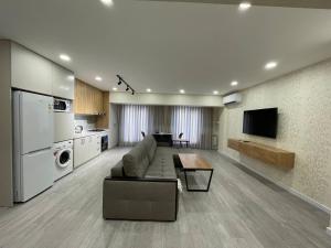 ein großes Wohnzimmer mit einem Sofa und einem TV in der Unterkunft Chorsu Apartment 2 in Taschkent