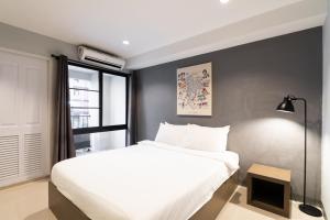 a bedroom with a large white bed and a window at North Inn Town Chiangmai in Chiang Mai