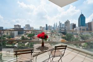 a balcony with a table with a vase of flowers on it at Regalia Residence @ KLCC View Sky Pool by MC in Kuala Lumpur