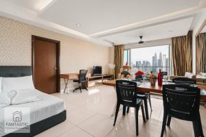 a hotel room with a bed and a table and chairs at Regalia Residence @ KLCC View Sky Pool by MC in Kuala Lumpur +274 photos