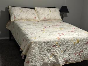 a bed with a white comforter with flowers on it at Walk to the Cowboys Game! Luxury Apt sleeps 4! in Arlington