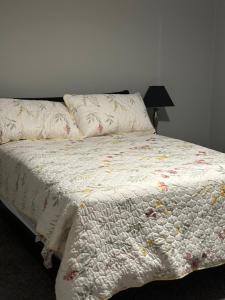 a bed with a comforter and a pillow on it at Walk to the Cowboys Game! Luxury Apt sleeps 4! in Arlington