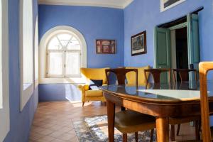 a dining room with blue walls and a table and chairs at Palazzo Santa Maria - Fondazione Meeting del Mare C.R.E.A. in Camerota