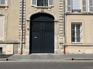 uma porta preta no lado de um edifício em CHIC Appartement Type 4 / Parking Privé em Reims