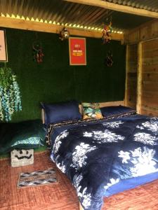 a bed in a room with a green wall at Shanti People Huts & Camp in Kasol