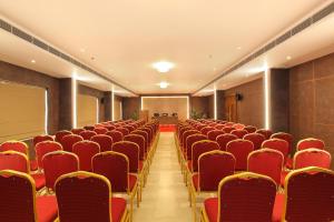 an empty conference room with red chairs and a screen at HOTEL MARIA PARK in Mūvattupula