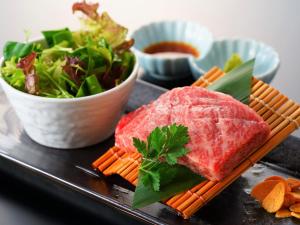 un plato de comida con carne y ensalada en Beppu Fuga, en Beppu