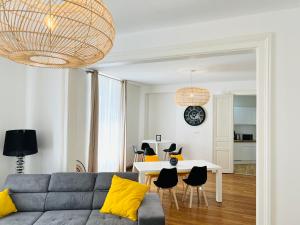 uma sala de estar com um sofá e uma mesa em CHIC Appartement Type 4 / Parking Privé em Reims