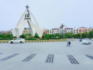uma torre de relógio no meio de um parque de estacionamento em SPACE Luxury Rental Suites em Rawalpindi