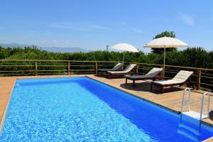 - une piscine avec 2 chaises et un parasol dans l'établissement Giardino Arancio - casa vacanze, à Giarre