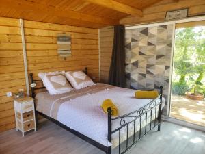 a bedroom with a bed and a large window at Escale Détente en amoureux Spa en option in Allan