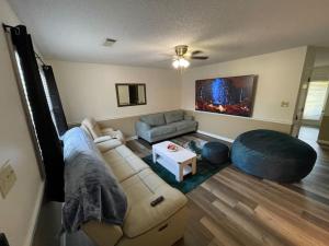 a living room with a couch and a table at NEW King Beds, 86 inch RokuTV, and Massage at the Comfort Haven in Commerce