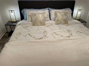 a white bed with two pillows and two night stands at NEW King Beds, 86 inch RokuTV, and Massage at the Comfort Haven in Commerce