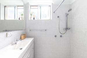 Un baño blanco con ducha y lavabo. en Fingal Bay Coastal Retreat 1 12 Marine Dr fantastic ground floor duplex, en Fingal Bay 30 fotos más