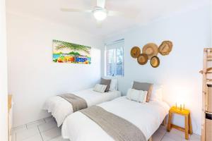 two beds in a room with white walls at Fingal Bay Coastal Retreat 1 12 Marine Dr fantastic ground floor duplex in Fingal Bay
