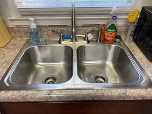 a stainless steel kitchen sink with two faucets at NEW King Beds, 86 inch RokuTV, and Massage at the Comfort Haven in Commerce