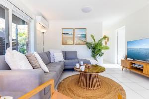 una sala de estar con un sofá y una mesa en Fingal Bay Coastal Retreat 1 12 Marine Dr fantastic ground floor duplex, en Fingal Bay