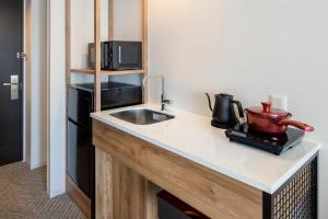 a kitchen with a sink and a microwave at Tokyu Stay Shinjuku Eastside in Tokyo