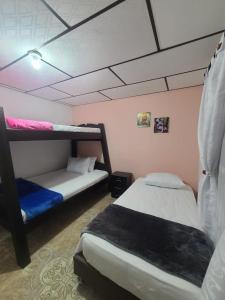 1 Schlafzimmer mit 2 Etagenbetten und rosa Wänden in der Unterkunft Vivienda Turistica Cattleya in Filandia