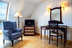 um quarto com uma cadeira, uma secretária e um espelho em Barrow Lodge em Tralee