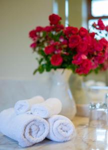 ein Strauß roter Rosen und Handtücher auf dem Tisch in der Unterkunft Barrow Lodge in Tralee