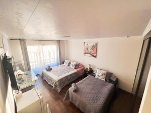 Habitación pequeña con 2 camas y sofá en Habitaciones en casa de alojamiento sector sur de Iquique, Chile en Iquique