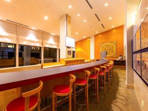 a bar with a row of stools in a restaurant at Nichinankaigan Nango Prince Hotel in Nichinan