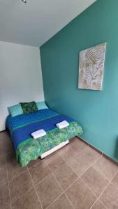 um quarto com uma cama numa parede azul em Castèléma - Appartement proche du sanctuaire em Lourdes