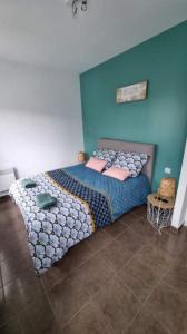 um quarto com uma cama grande e uma parede azul em Castèléma - Appartement proche du sanctuaire em Lourdes