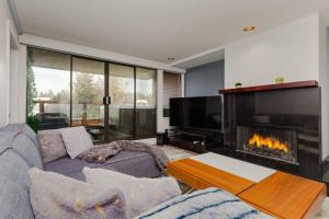 a living room with a couch and a fireplace at Patagonia 2 Bed 2 Bath with Private Hot Tub in Whistler