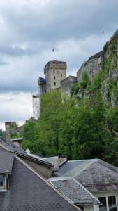 un château au sommet d'une colline avec des toits dans l'établissement Castèléma - Appartement proche du sanctuaire, à Lourdes