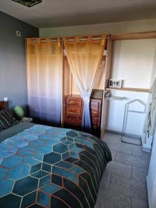 a bedroom with a large bed and a kitchen at LA CAZAKANEL in Petite Île