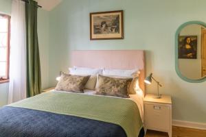 een slaapkamer met een bed met een blauw dekbed en een spiegel bij Boho Chic Apartment Stellenbosch in Stellenbosch
