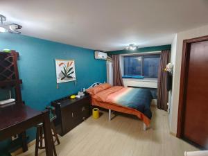 sypialnia z łóżkiem, biurkiem i oknem w obiekcie Yu Jing Xuan Boutique Apartment w mieście Tiencin