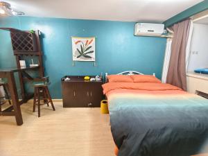 1 dormitorio con cama y pared azul en Yu Jing Xuan Boutique Apartment, en Tianjin